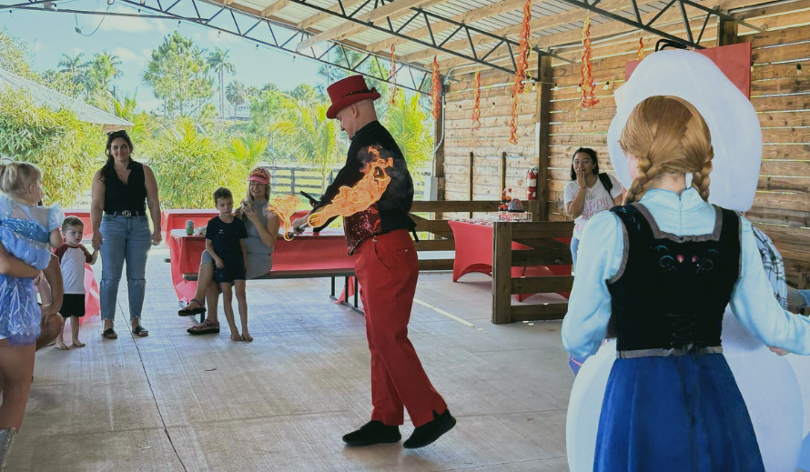 Children enjoying a birthday party at Hobe Sound Farms with live entertainment and characters inside a rustic barn venue