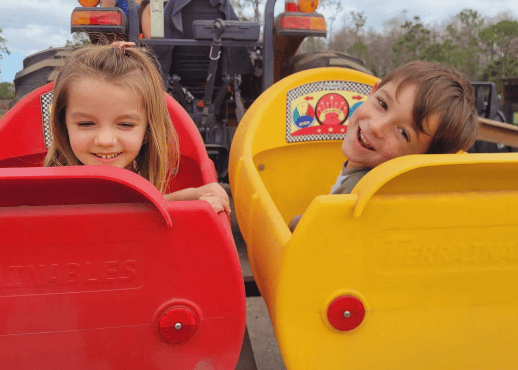 Children smiling on barrel ride attraction at Hobe Sound Farms