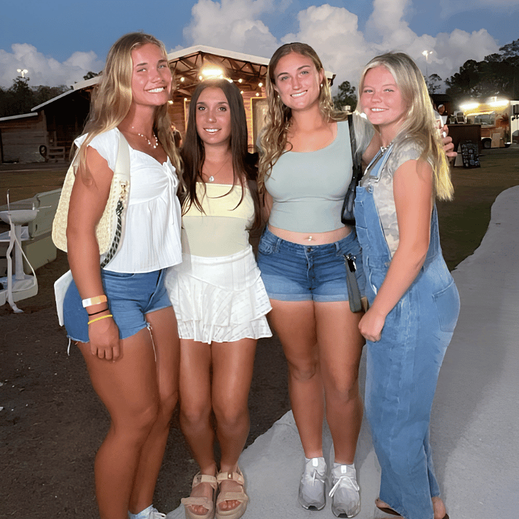 Friends posing together during an evening event on the farm