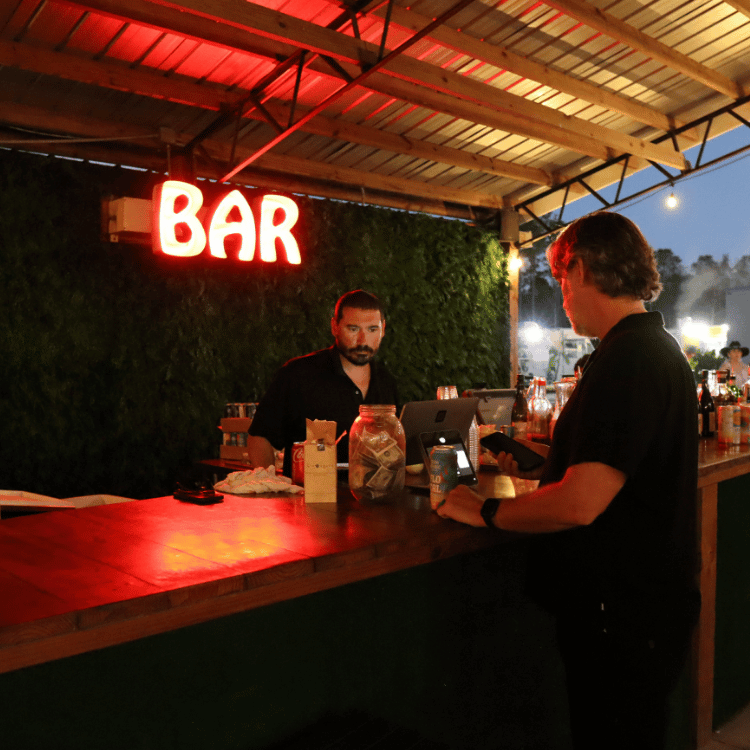 Bartender serving drinks during an evening farm event