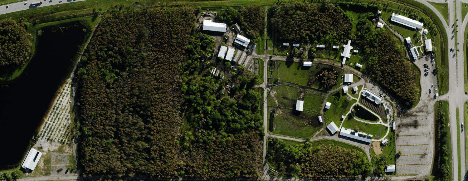 Drone view of Hobe Sound Farms showcasing event spaces, barns, pastures, and natural landscapes.